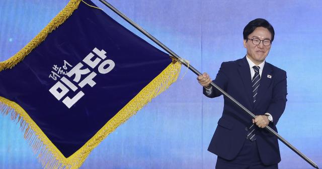 김민석 더불어민주당 신임 당 대표가 17일 대전 컨벤션센터에서 열린 제3회 더불어민주당 정기 전국당원대회에서 당 대표로 선출된 뒤 당기를 흔들어 보이고 있다 사진연합뉴스