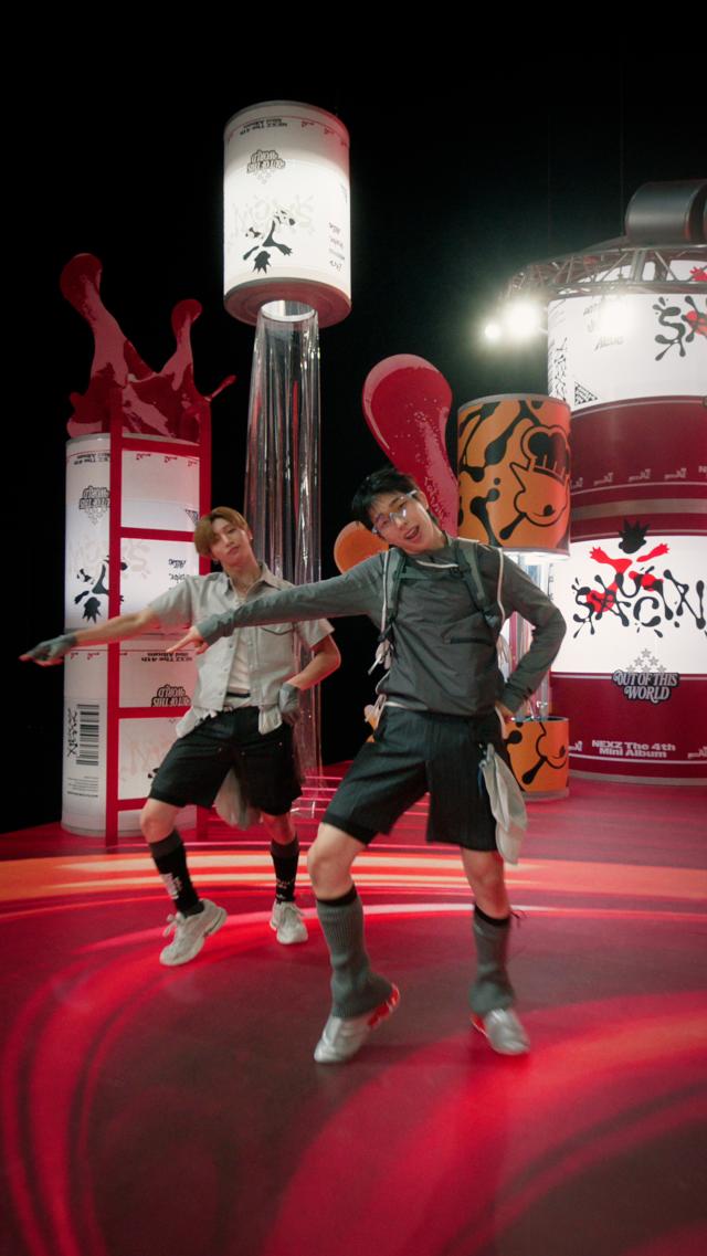 Two members of NEXZ perform a dance move from the SAUCIN performance challenge in an image released by JYP Entertainment to promote the routine ahead of the groups Aug 24 comeback Courtesy of JYP Entertainment