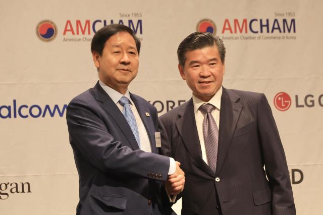 Deputy Prime Minister and Minister of Finance and Economy Koo Yun Cheol left shakes hands with AMCHAM Chairman and CEO James Kim at the Grand Hyatt Seoul on Aug 19 2026 AJP Han Jun-gu 