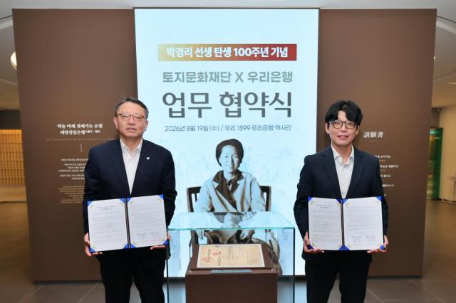 19일 박경리 선생 탄생 100주년을 기념해 열린 우리은행과 토지문화재단의 문화협력을 위한 업무협약식에서 정진완 우리은행장왼쪽과 김세희 토지문화재단 이사장이 우리은행 역사관 우리1899에서 기념사진을 촬영하고 있다 사진우리은행
