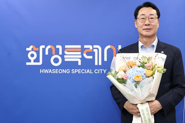 정명근 화성특례시장이 대한민국대도시시장협의회 제23대 회장으로 선출된 뒤 축하 꽃다발을 들고 기념촬영을 하고 있다 사진화성시