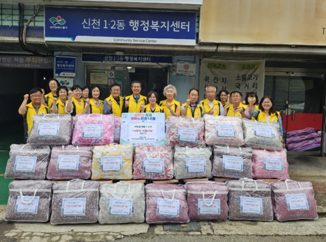 대구 동구 신천1·2동 지역사회보장협의체·민간사회안전망 관계자들이 취약계층에 전달할 춘추이불과 함께 기념 촬영을 하고 있다사진대구 동구
