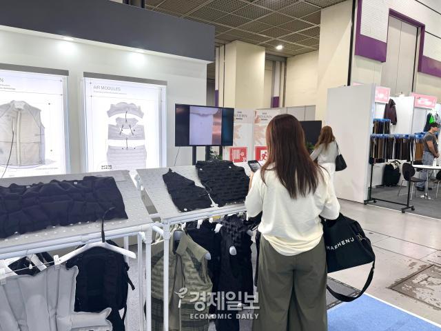 커버써먼 부스에 전시된 의류를 둘러보는 관람객 모습 사진정보운 기자
