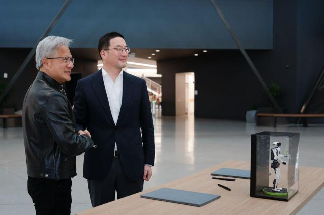 Nvidia CEO Jensen Huang right poses for a photo with LG Chairman Koo Kwang-mo with a miniature humanoid robot after signing an MOU in Santa Clara California on Aug 13 Courtesy of Nvidia