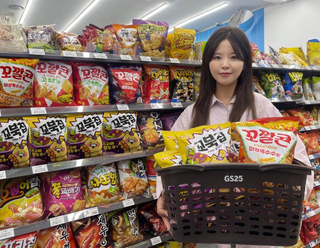 GS25에서 모델이 춘식이 꼬북칩 고구마탕후루맛과 꼬깔콘마성옥수수맛을 들고 포즈를 취하고 있다 사진GS25