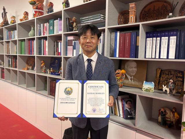 A representative of Hansae Mobility holds a certificate of appreciation presented by the Embassy of Uzbekistan in Seoul on Aug 26 2026 AJP Ryu Yuna