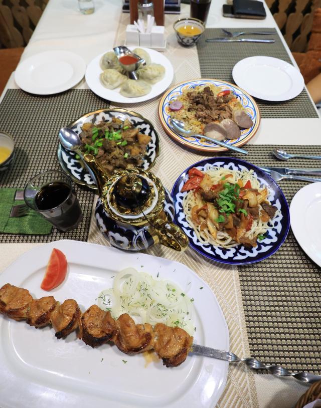 A spread of Central Asian dishes including grilled meat dumplings noodles and rice is served at a restaurant in Astana Kazakhstan AJP Han Jun-gu