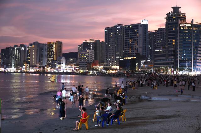 23일 부산 수영구 광안리해수욕장에서 여전한 폭염과 열대야를 피해 나온 시민과 관광객들이 해변에 놓인 의자에 앉아 저녁 바닷바람을 쐬며 더위를 식히고 있다 사진연합뉴스