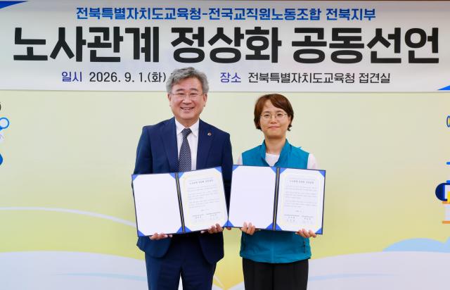 천호성 전북특별자치도교육감왼쪽과 오도영 전교조 전북지부장이 1일 노사관계 정상화 공동선언문을 들고 있다사진전북특별자치도교육청