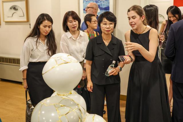 A guide discusses a gold-seamed ceramic sculpture with visitors at “Italy at Frieze: The Golden Trace” in Seoul on Sept. 1, 2026. The exhibition explores fracture, repair and regeneration through works by Korean and Italian artists.AJP Yoo Na-hyun