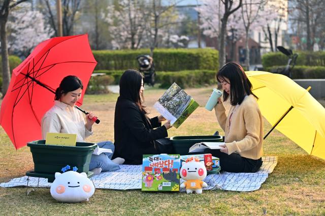 하남시 9개 공공도서관이 9월 독서의 달을 맞아 108개의 다채로운 독서문화행사를 개최한다 사진은 미사누리공원 2호 잔디밭에서 돗자리에 앉아 피크닉세트 속 그림책을 펼치며 독서를 하는 모습 사진하남시