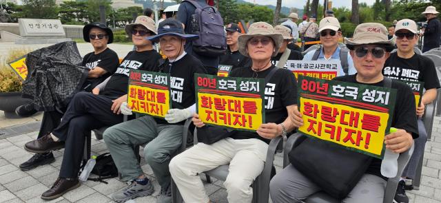 Protesters hold signs opposing the proposed integration of South Korea’s Army Navy and Air Force academies outside the War Memorial of Korea in Seoul on Aug 26 2026 AJP Kim Hee-su