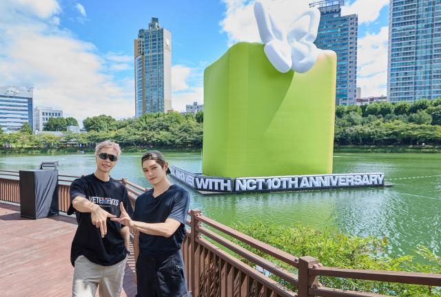 NCT 127's Johnny (left) and Taeyong pose near an art balloon marking NCT's 10th anniversary at Seokchon Lake on Sunday. Below, WayV's Kun (left) and Yangyang visit the NCT x Seoul Fashion Week photo zone, while NCT DREAM's Jisung tours the costume exhibition.