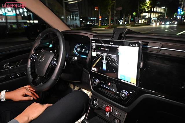 The interior of a self-driving taxi in Seoul with a passenger seated beside the vehicles autonomous driving display Courtesy of Seoul Metropolitan Governments My Seoul webzine