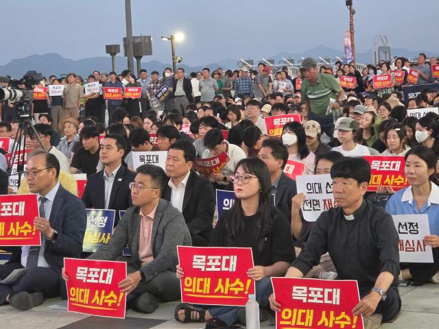 7일 오후 7시 목포 평화광장을 가득메운 전남 서남권 주민들이 목포대 의대사수란 손 펫말을 들고 있다사진김옥현 기자