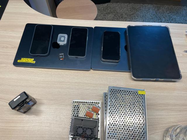 Phones tablets storage devices and computer hardware seized from suspects are laid out during the joint raid in Thailand Courtesy of the Ministry of Culture Sports and Tourism