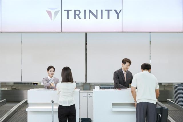 트리니티항공 직원들이 새로운 CI를 적용한 인천국제공항 탑승 수속 카운터에서 고객을 맞이하고 있다사진트리니티항공
