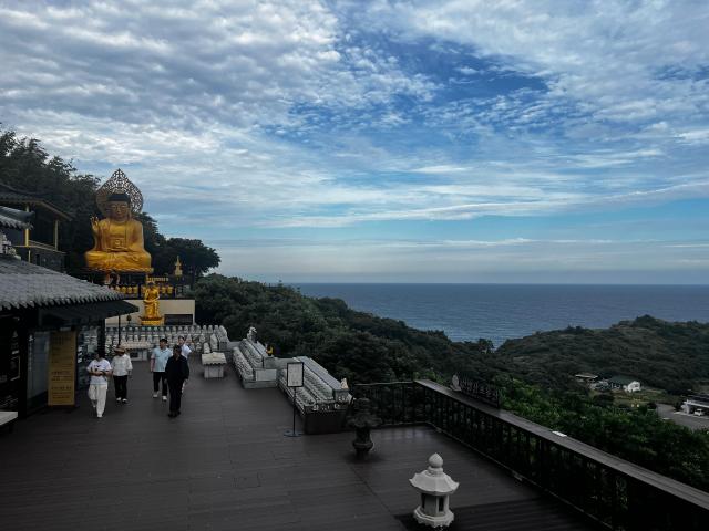 A view of the sea from Hyangiram Hermitage in Yeosu South Jeolla Province with a Buddhist statue overlooking the coastline AJP Joonha Yoo