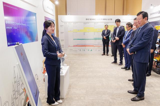 롯데는 10일 롯데월드타워에서 2026 롯데 디자인전략회의를 개최했다고 밝혔다 신동빈 롯데 회장오른쪽 첫 번째이 젊은 디자이너들의 인공지능AI 프로젝트 결과물인 로티로리 로봇 롯데월드 안내 서비스에 대한 설명을 듣고 있다사진롯데