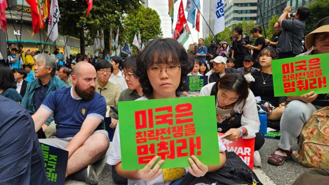 Ha Ji-won a 23-year-old philosophy student at Soongsil University holds a placard reading “Stop the US war of aggression” during a rally opposing South Korea’s possible deployment to the Strait of Hormuz in Jongno Seoul Sept 12 2026 AJP Lee Jung-woo 