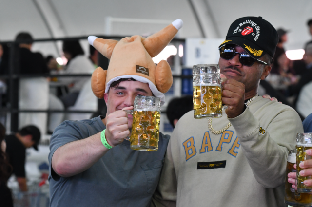 Festivalgoers raise glasses of German beer inside the Big Tent during Oktoberfest Seoul 2026 at Oil Tank Culture Park in western Seoul on Sept. 12, 2026. One visitor wears a chicken-shaped novelty hat sold at the festival. AJP Joonha Yoo