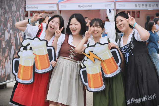 Friend group dressed in Bavarian-style outfits pose with beer-mug props during Oktoberfest Seoul 2026 at Oil Tank Culture Park in western Seoul on Sept 12 2026 AJP Joonha Yoo