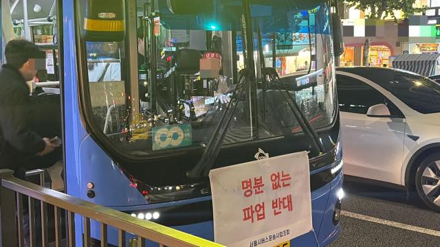 지난 15일 저녁 서울의 한 시내버스. 앞유리엔 사측이 붙인 '파업 반대' 문구가, 운전석 기사의 머리엔 '단결투쟁' 머리띠가 보인다. [사진=방효정 기자]