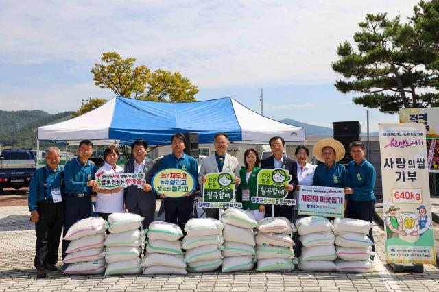 한국생활개선칠곡군연합회와 한국농촌지도자칠곡군연합회 회원 및 관계자들이 14일 칠곡종합운동장에서 열린 ‘2026년 생활개선회·농촌지도자회 한마음대회’에서 어려운 이웃을 위한 사랑의 쌀 640㎏을 전달한 뒤 기념 촬영을 하고 있다사진칠곡군