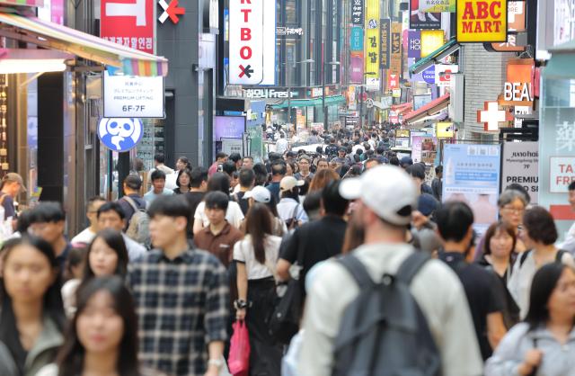 首尔明洞街头游客和市民络绎不绝。【图片来源 韩联社】