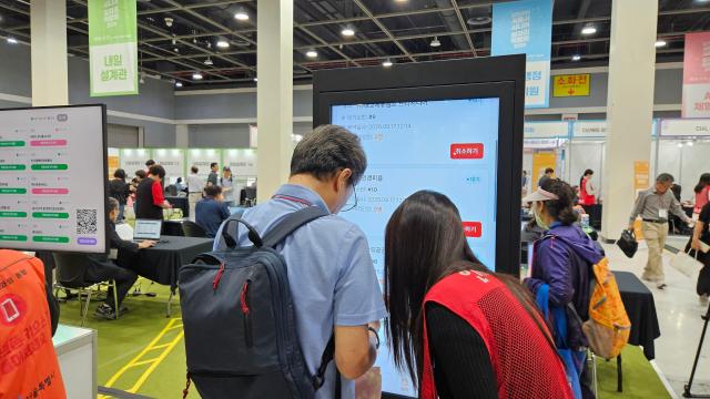 A “Digital Helper” assists an older job seeker with using a kiosk during the Seoul Senior Job Fair 2026 at the aT Center in Seocho-gu Seoul Sept 17 2026 The fair stationed helpers around the venue to guide senior visitors through digital registration reservations and other smartphone- and kiosk-based services AJP Lee Jung-woo