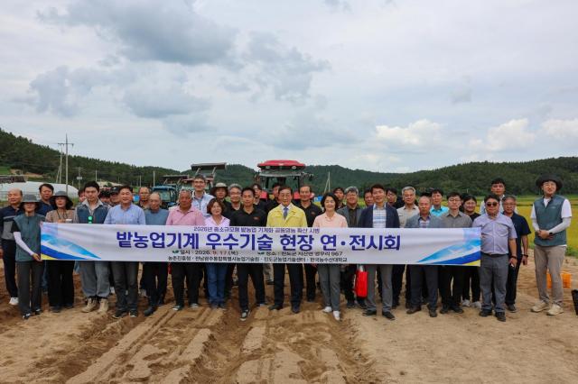 17일 진도군 지산면 앵무리 일원에서 열린 ‘밭농업기계 우수기술 현장 연·전시회’ 참석자들이 밭농업 기계화 장비를 배경으로 기념촬영을 하고 있다 이날 행사에서는 배추 파종부터 정식·수확까지 전 과정에 적용할 수 있는 농기계와 관련 기술이 시연·전시됐다 사진진도군