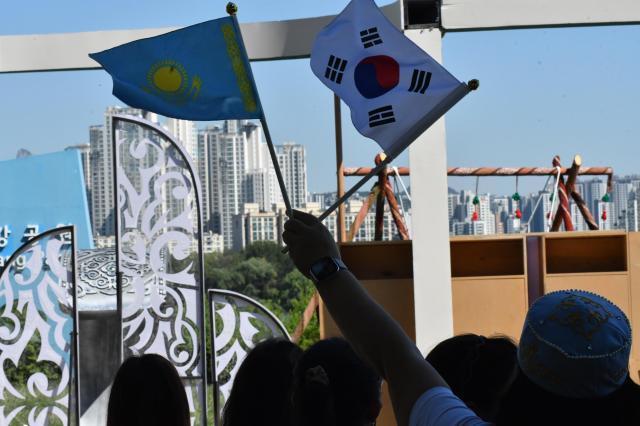 A participant waves the flags of Kazakhstan and South Korea during the Korea-Kazakhstan Cultural Heritage Exchange at Yeouido Hangang Park in Seoul on Sept 16 2026 AJP Joonha Yoo