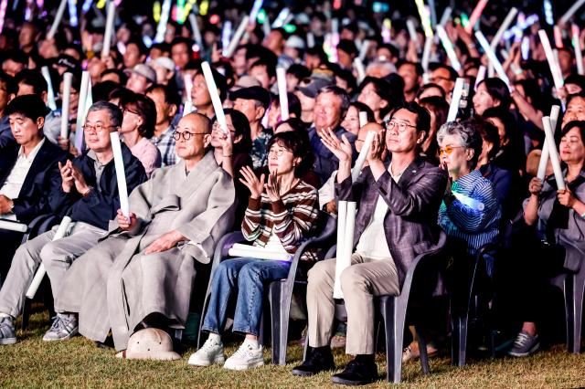정명근 화성특례시장맨 앞줄 오른쪽 첫 번째이 19일 정조효공원에서 열린 2026 병점구 모두의 행복 콘서트에서 시민들과 함께 공연을 관람하며 박수를 치고 있다 사진화성시