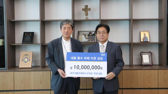 성한기 대구가톨릭대 총장오른쪽이 18일 조환길 타대오 천주교 대구대교구 교구장에게 네팔 홍수 피해 복구와 이재민 지원을 위한 성금 1000만원을 전달하고 있다 사진대구가톨릭대