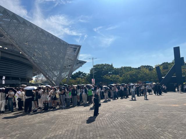 Fans line up beneath KSPO Domes angular entrance canopy before doors open for an NCT 127 concert AJP Joonha Yoo