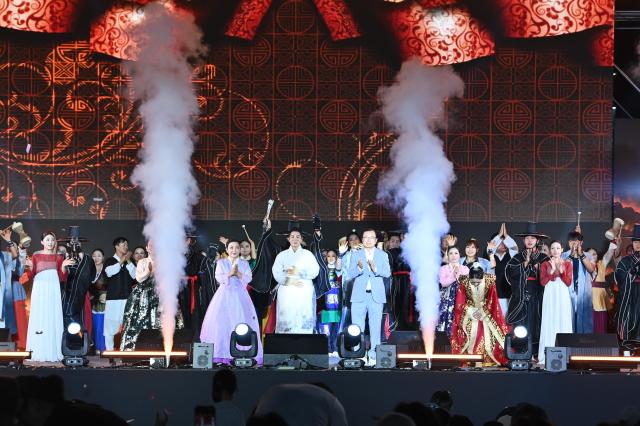 지난 19일 미사호수공원 잔디광장에서 열린 ‘2026 하남이성산성문화제’ 개막식에서 이현재 하남시장이 전통 의상을 입은 지역 예술인들과 함께 개막 주제공연을 선보인 뒤 관객들에게 박수로 화답하고 있다 사진하남시