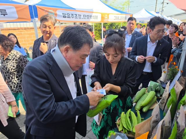 김산 무안군수가 21일 추석을 앞둔 마지막 장날을 맞아 일로전통시장에서 열린 ‘온마을 예술장터’를 찾아 지역 농산물을 직접 구매하며 상인들을 격려하고 있다 이날 장터에서는 지역예술인 공연과 체험 프로그램 로컬푸드 판매 등이 함께 펼쳐져 명절을 앞둔 전통시장에 활기를 더했다사진 김옥현 기자