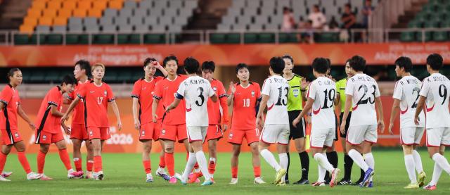21日、日本静岡県袋井の静岡スタジアムエコパで行われた2026愛知・名古屋アジア大会女子サッカーグループリーグ、韓国と北朝鮮の試合で引き分けた両チームの選手たちが試合後に挨拶を交わしている。写真＝聯合ニュース