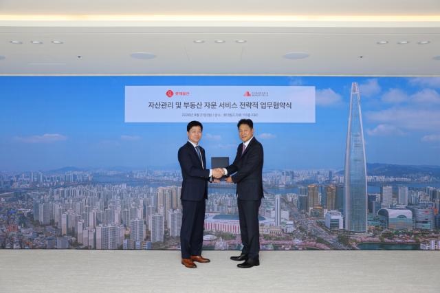 롯데월드타워 113층 EBC에서 쿠시먼앤드웨이크필드 코리아 황점상 대표사진 우측와 롯데물산 장재훈 대표가 전략적 업무협약MOU 체결 후 기념촬영을 하고 있다 사진쿠시먼앤드웨이크필드 코리아