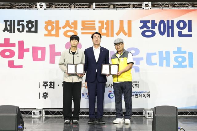 정명근 화성특례시장이 제5회 화성특례시 장애인 한마음체육대회에서 장애인 체육 발전 유공자들에게 표창을 수여하고 기념촬영을 하고 있다 사진화성시