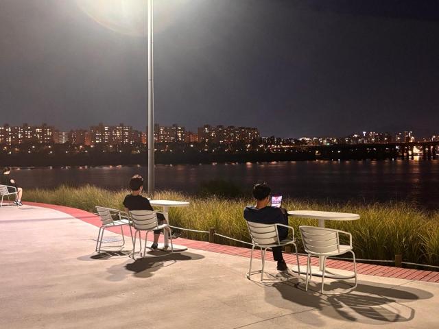 People sit by the Han River in Seongsu-dong eastern Seoul on the evening of Sept 20 2026 AJP Ryu Yuna