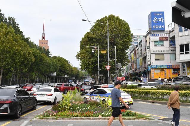 The busy road outside Eunma Sangga, lined with plane trees, local shops, and the iconic blue Eunma sign in the distance on Sept 25. AJP Joonha Yoo