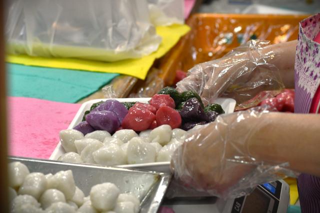 A rainbow colored songpyeon (Korean rice cakes) — purple, pink, and green — freshly packed for customers on Sept 25. AJP Joonha Yoo