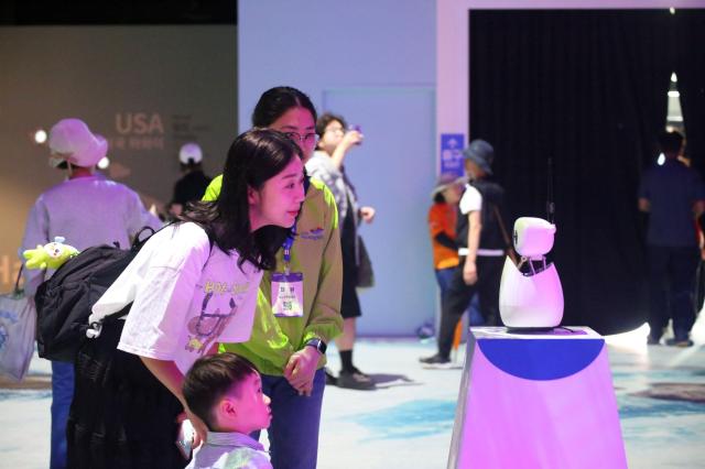 추석 연휴를 맞아 2026여수세계섬박람회장을 찾은 가족 관람객이 주제섬에서 ‘AI 다섬이 도슨트’와 대화를 나누며 전시 콘텐츠를 체험하고 있다 AI 다섬이 도슨트는 관람객의 질문에 답하며 전시 내용과 박람회 정보를 안내한다사진재2026여수세계섬박람회 추진위원회