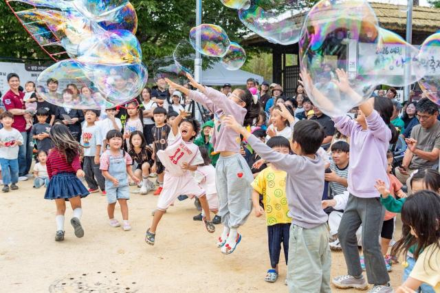 ‘2026 예천 삼강나루주막축제’를 찾은 어린이들이 버블쇼에서 만들어진 대형 비눗방울을 잡으며 즐거운 시간을 보내고 있다 사진예천군