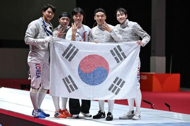 2026 아이치·나고야 아시안게임 펜싱 남자 사브르 단체전에서 4연패를 달성한 대한민국 대표팀 선수단이 국민 응원 메시지가 담긴 태극기를 들고 기념 사진을 찍고 있다 사진SKT