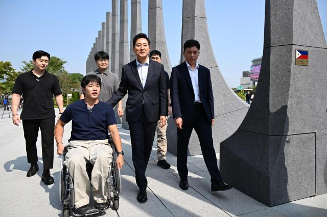 오세훈 서울시장이 30일 서울 광화문광장 감사의정원에서 청년부상제대군인들을 만나 대화하며 걷고 있다 사진서울시