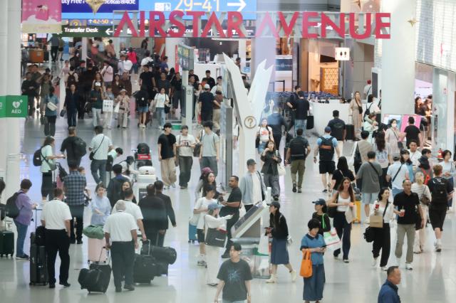 仁川国际机场免税店区域旅客络绎不绝。【图片来源 韩联社】