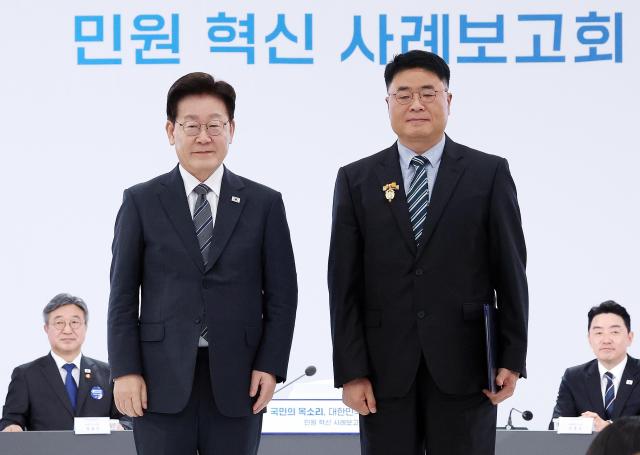 이재명 대통령이 2일 세종특별자치시에서 열린 ‘국민의 목소리 대한민국을 바꾼다’ 민원 혁신 사례보고회에서 김정환 경기 화성시 주차시설팀장에게 대통령 표창을 수여하고 기념촬영을 하고 있다 사진뉴시스