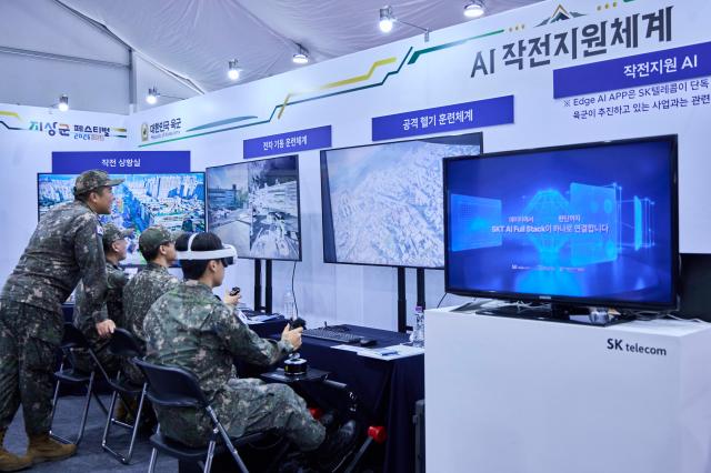 SKT 전시 부스를 찾은 군 관계자들이 ‘AI 참모AI 작전 지원 체계’를 체험하고 있는 모습사진SKT